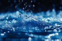 Dynamic water splash with crown-shaped droplets against dark blue bokeh background, capturing liquid motion and crystalline drops in macro photography.
