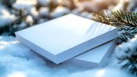 White blank book mockup in winter snow with evergreen branches for holiday branding and seasonal marketing campaigns.