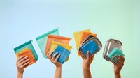 Diverse hands holding colorful books against pastel sky background promoting education, reading culture and knowledge sharing in community.