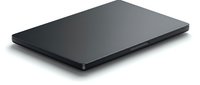 Closed slim dark laptop on white background, isolated. Sleek matte black portable computer, side view showing thin profile and modern design.