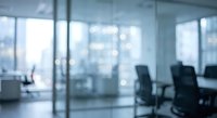 Blurred modern office interior with glass walls and conference room chairs creating professional corporate workspace atmosphere for business presentations.