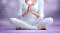 Young Asian woman in white clothing sitting in lotus position with prayer hands against purple background with magical sparkle effects, wellness and meditation concept.