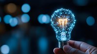 Glowing light bulb with blue digital network pattern held against blurred bokeh background, representing innovation and technological advancement in business.
