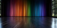 Vibrant rainbow-colored stage curtains in theater with wooden floor and natural light through windows, creating dramatic spectrum reflection on polished surface.