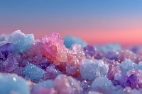 Colorful crystal formation with blue, purple, and pink minerals against a dreamy sunset sky background.
