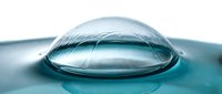 Transparent water droplet dome resting on liquid surface with ripples, isolated on white background for design and scientific applications.