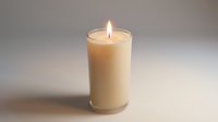 Burning cream colored pillar candle with bright flame on neutral background for relaxation and home decor concepts.