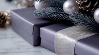 Silver wrapped holiday presents with metallic ribbon, pine branches, ornaments and pinecones on neutral background, elegant festive composition for seasonal decor.