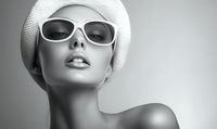 Elegant female mannequin wearing white sunglasses and knit hat, monochrome fashion portrait with bare shoulders against neutral background.