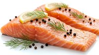 Fresh salmon fillets with dill herbs and black peppercorns on white background. Raw fish steaks seasoned with spices for cooking and culinary preparation.