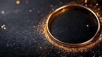 Golden wedding ring on dark background with magical glowing sparkles and bokeh lights creating romantic atmosphere for marriage proposal.