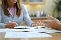 Close-up of business meeting with hands gesturing over documents, showing collaboration between professionals discussing paperwork in office environment.