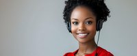 Young African American woman wearing red sweater and wireless headphones smiling confidently against light gray background, panoramic crop.