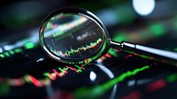 Magnifying glass focused on financial market data showing stock price movements with red and green candlestick charts on digital display screen.