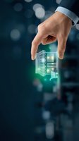 Businessman hand holding glowing holographic building and shopping cart icon for real estate, e-commerce, and digital technology concepts.