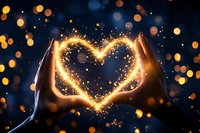 Silhouetted hands forming heart shape with magical glowing sparkles and bokeh lights against dark background, creating romantic atmosphere.