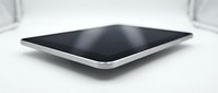 Modern black tablet computer with silver frame lying flat on white surface, sleek design for technology and digital device concepts.