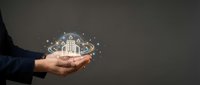 Businessman hands holding glowing digital building with network connections representing smart city technology and real estate innovation concept.