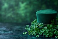 Green leprechaun hat surrounded by fresh clover leaves on dark stone background, creating magical St. Patrick's Day holiday atmosphere.