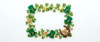 St. Patrick's Day frame made with green shamrock clovers, gold coins, and leprechaun hats arranged in a border on white background for holiday celebrations.