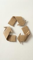 Recycling symbol made from torn cardboard pieces arranged on white background, representing environmental sustainability and waste management for eco-friendly design projects.