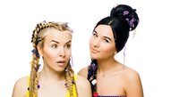 Young women with elaborate braided hairstyles adorned with colorful flowers and beads, displaying creative hair styling and beauty looks for fashion and editorial use.