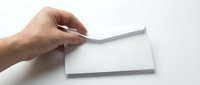 Male hand holding blank white envelope on white background, isolated design element for business correspondence and mail mockup projects.