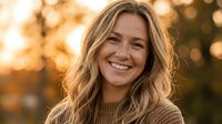 Happy blonde woman smiling warmly during golden hour sunset with soft bokeh background for lifestyle and wellness content.