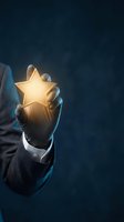 Businessman hand holding glowing golden star symbol representing excellence, achievement, success rating and premium quality service on dark background.