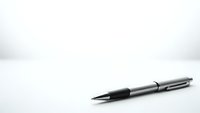 Modern silver ballpoint pen with black grip on clean white surface for business and office use.