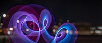 Abstract neon spiral energy waves in purple and blue colors creating dynamic motion effect against dark background for modern digital art projects.