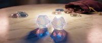 Colorful translucent polyhedral dice scattered on wooden surface with fabric pouch, perfect for tabletop gaming and role-playing adventures.