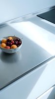 Bowl of fresh cherries and apricots on modern kitchen countertop with natural sunlight, minimalist interior design and clean surfaces.