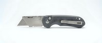 Professional folding utility knife with gray handle and sharp blade isolated on white background for cutting tasks and workshop projects.