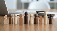 Diverse wooden figurines representing multicultural team unity and inclusion concepts for business presentations and corporate diversity training materials.