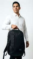 Young man of Latin American descent wearing white button-up shirt holding black laptop backpack against white background. Suitable for business, travel, education, and corporate lifestyle content.