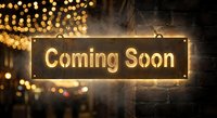 Golden coming soon sign with warm bokeh lights and atmospheric smoke for business announcements and promotional campaigns.