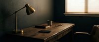Wooden desk with brass desk lamp and office supplies in minimalist workspace with natural window light for professional work environment.
