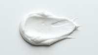 Creamy white cosmetic product smear or skincare lotion sample isolated on white background, ready for beauty and wellness design projects.
