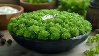 Fresh green curly parsley in black ceramic bowl on wooden table with salt crystals, herbs and spices arrangement for cooking and garnishing food.