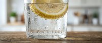 Refreshing glass of sparkling water with fresh lemon slice and ice cubes on wooden surface, perfect for beverage, wellness, and lifestyle design projects.