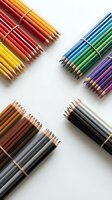 Organized bundles of sharpened colored pencils in warm reds, yellows, cool blues, greens, purples, browns, and neutrals arranged on white background for art and design projects.