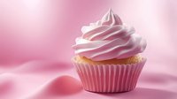 Pink frosted cupcake with swirled cream topping in pastel paper wrapper on soft pink background with gentle shadows, perfect for bakery marketing and dessert menus.