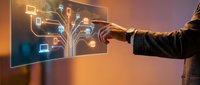 Businessman hand touching digital tree interface with glowing device icons on transparent screen, representing technology network and digital transformation solutions.