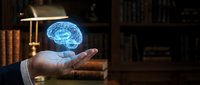 Businessman hand holding glowing blue brain hologram in dark library office representing artificial intelligence, neuroscience and innovative thinking.