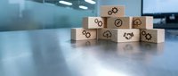 Wooden blocks with business icons arranged on modern office desk representing strategy, teamwork, and corporate planning concepts for presentations.