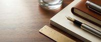 Elegant fountain pen and stationery set on wooden desk surface for professional writing, business correspondence, and office work applications.