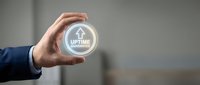 Businessman hand holding glowing uptime guarantee icon with arrows symbolizing reliable service and continuous operation for business technology solutions.