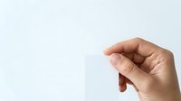 Adult hand holding blank white card against neutral background, suitable for business branding, marketing mockups, and promotional designs.