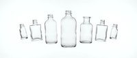 Empty clear glass bottles collection of various shapes and sizes isolated on white background for packaging design and craft projects.